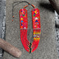 Colorful beaded necklace with geometric patterns on a textured surface