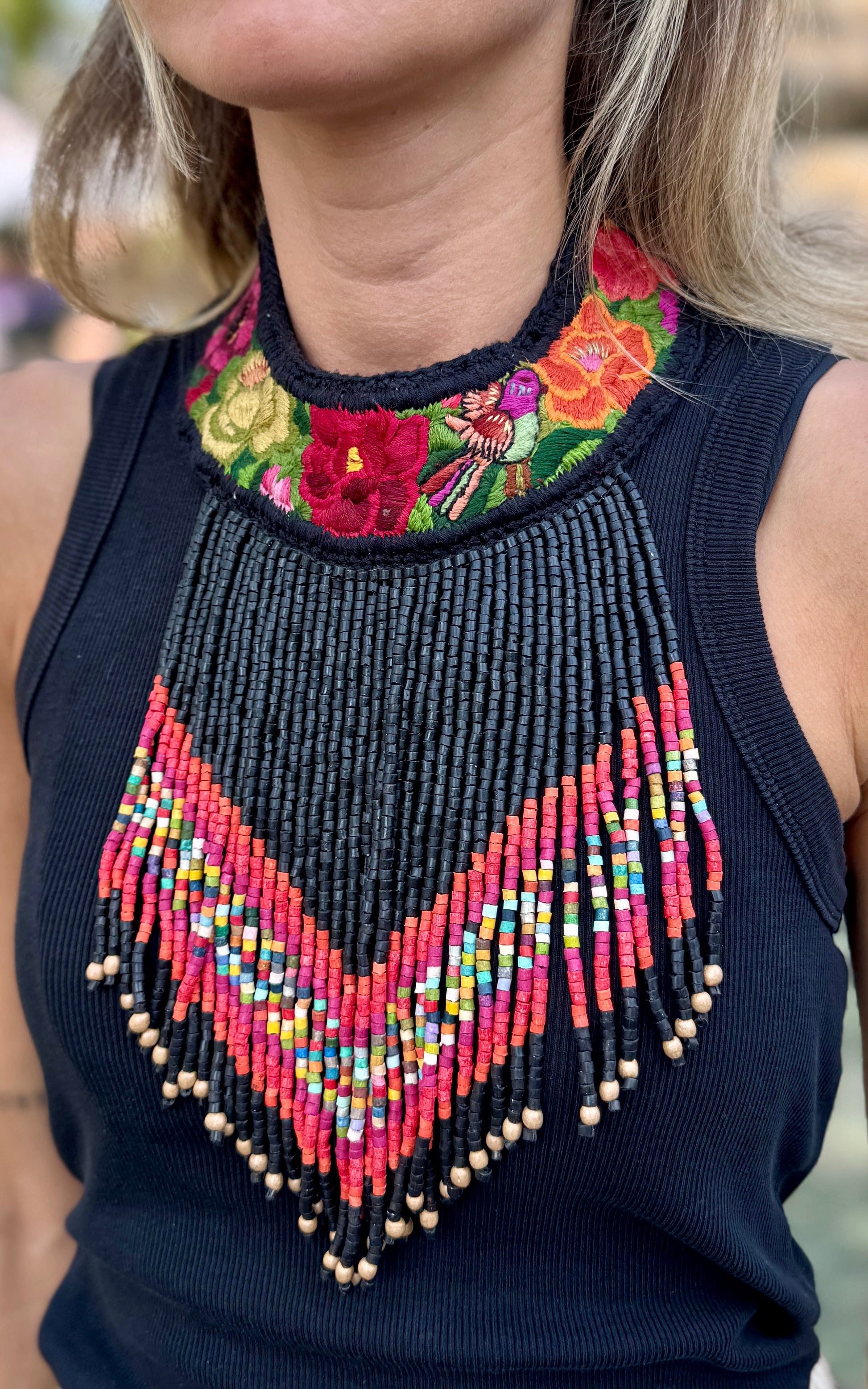 Bib necklace with colorful beaded design and floral embroidery.