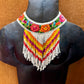 Colorful beaded necklace on a mannequin bust against a brown background