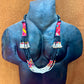 Necklace with colorful beads on a mannequin bust against a brown background