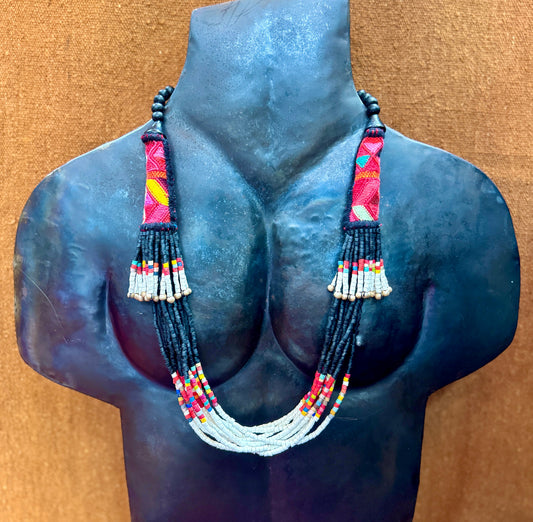 Necklace with colorful beads on a mannequin bust against a brown background