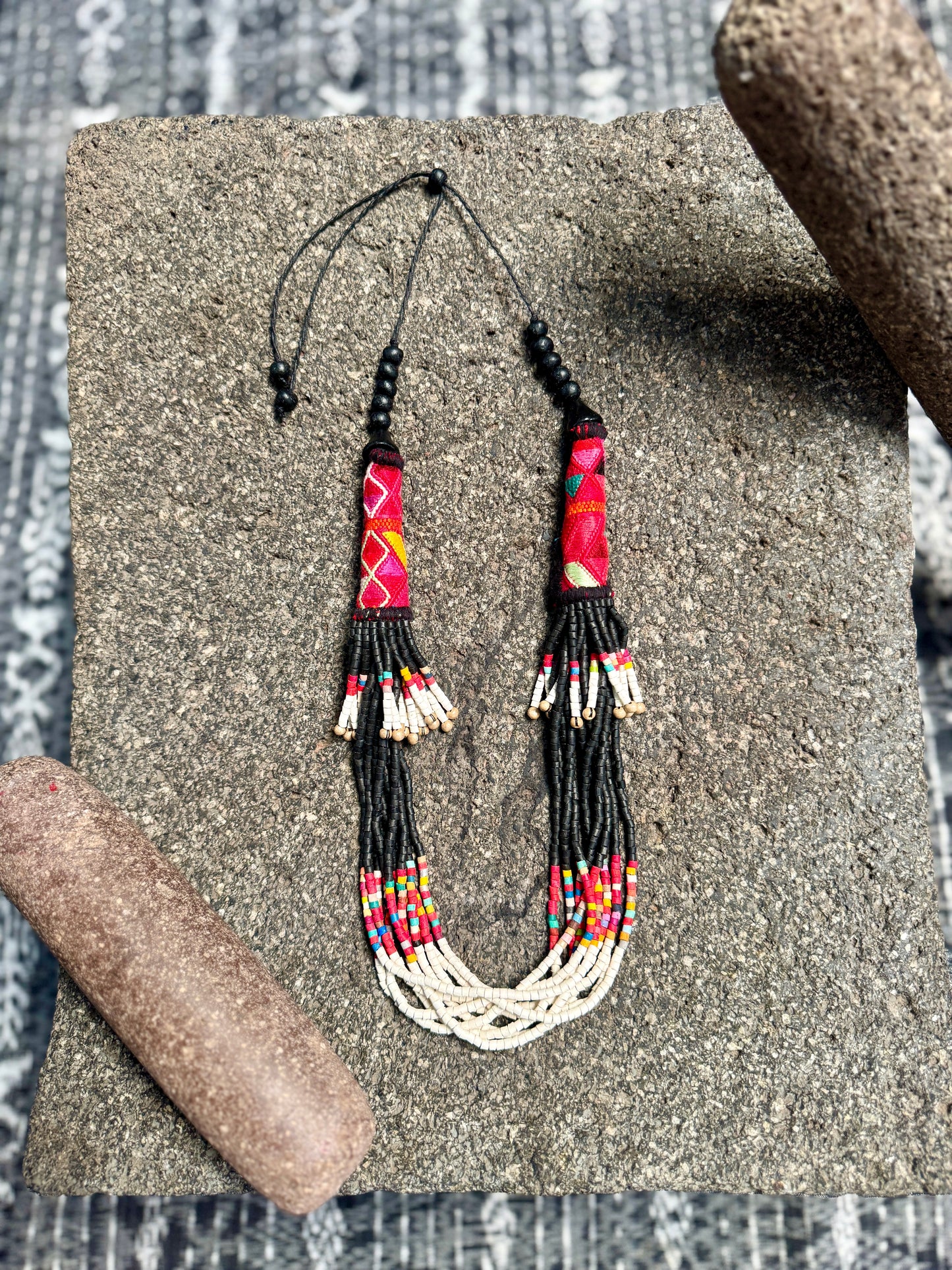 Colorful beaded necklace on a textured surface